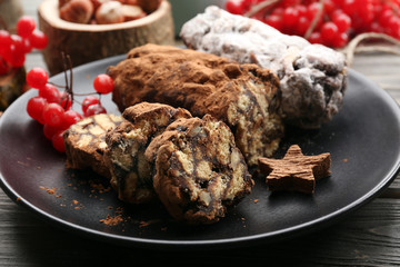 Chocolate salami in a plate on a wooden background, close up
