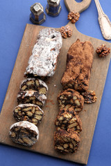 Chocolate salami on a chopping board over blue background