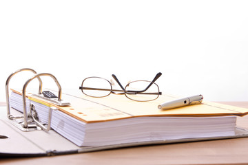 Hefter, Aktenordner, Lesebrille und Füller