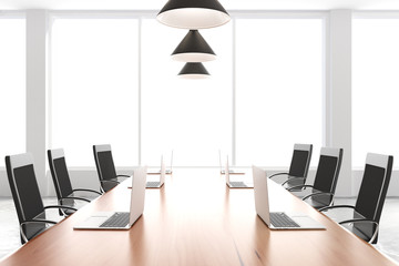 Modern conference room with furniture, laptops and big windows