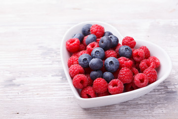 Fresh berries in heart shaped bowl 