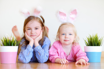 Two adorable little sisters wearing bunny ears on Easter