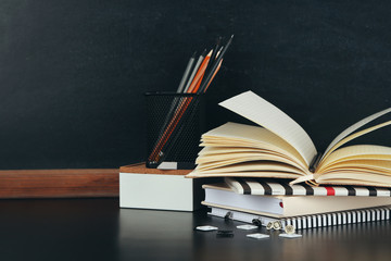 School supplies near blackboard, close up