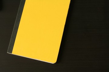 Yellow diary (notepad) on the black wooden table