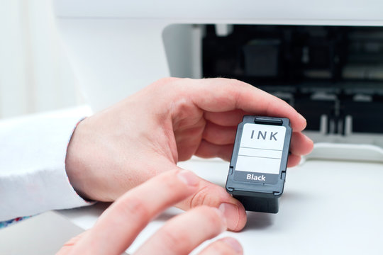 Man replace black ink cartridge in white printer