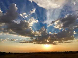 Fototapeta na wymiar Sun Rays Bursting Through Clouds