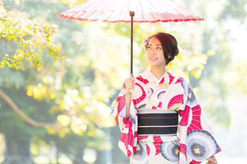 attractive asian woman wearing kimono walking in the park