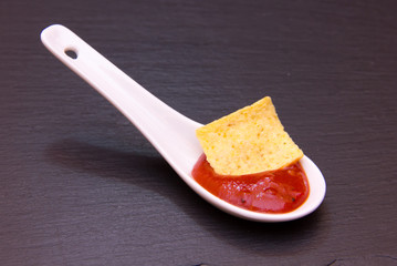 Teaspoon with hot sauce on top in slate