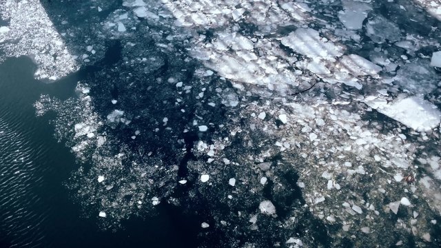 A high angle view of ice moving on a river or ocean in the winter.  	