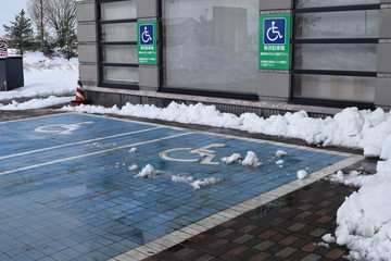 雪国の障害者用駐車場／雪国の山形県で、車椅子マークがペイントされた障害者用駐車場を撮影した写真です。約30cmの降雪後、除雪された冬イメージの風景です。