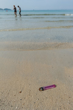 An old and broken lighter polluting the beach