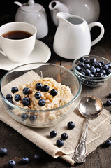 Oatmeal or porridge with blueberries and brown sugar. Healthy breakfast, toned image