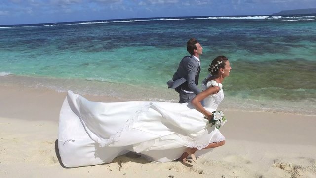 Just married couple running on a caribbean beach