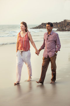 Happy Mixed Race Couple Walking On The Beach