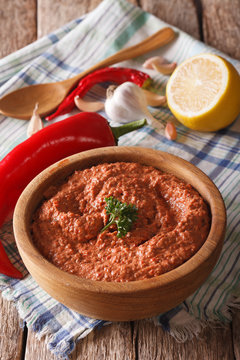 Red Muhammara and ingredients close-up. vertical
