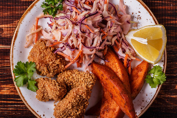 Homemade cooked nuggets, sweet potatoes and coleslaw.