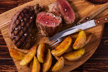 Grilled steak with potato wedges, salsa and spices.