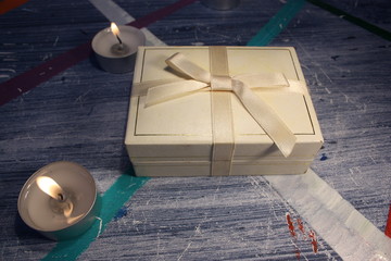 box with a gift and candle on the table side view