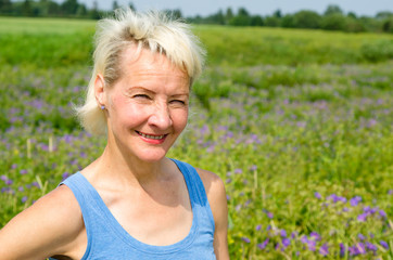Fototapeta na wymiar Portrait of a woman amid the summer meadows in the countryside