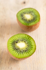 Eine halbierte Kiwi liegt auf einem Holzbrett