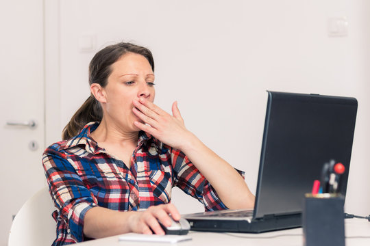 Photo of woman yawning at the office