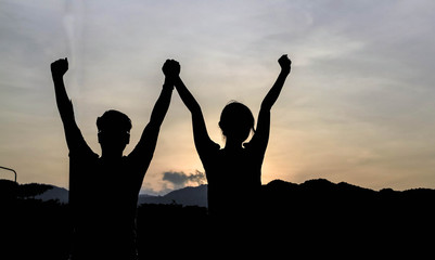 silhouette of man show arm up for achievements successful and celebrating success with sunrise