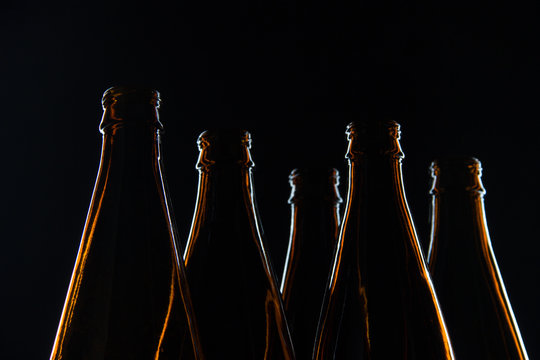 Silhouettes brown glass bottles for beer on a black background