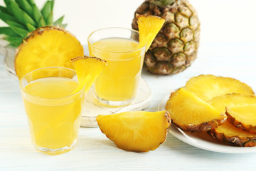 Fototapeta na wymiar Glasses of pineapple juice on a white wooden table