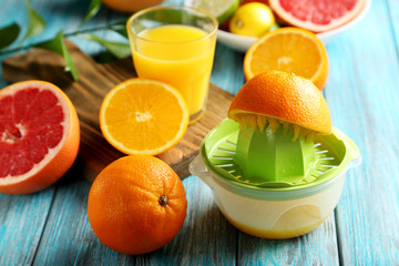Citrus fruits with juicer on a blue wooden table