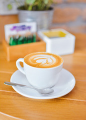 Obraz premium Hot milk art coffee on wooden table