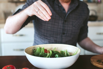 male hands preparing vegetarian salad in the kitchen