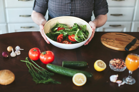 male hands preparing vegetarian salad in the kitchen