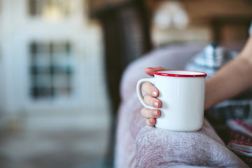 woman's hands holding a cup of tea, coffee from home
