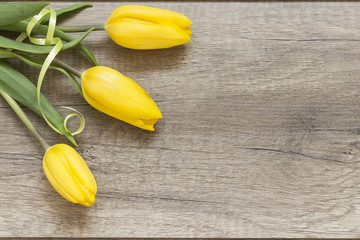 Żółte tulipany na drewnianych deskach - obrazy, fototapety, plakaty