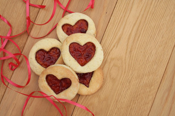 biscotti  a forma di cuore con marmellata su tavolo di legno.  San Valentino