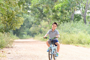 Naklejka premium Boy riding bicycle on the road.