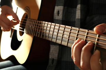 Fototapeta na wymiar Guitarist plays guitar on wooden background, close up