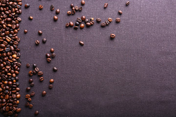 Roasted coffee beans on grey textile background