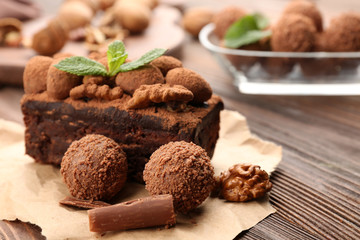 A piece of chocolate cake with walnut and mint on the table, close-up