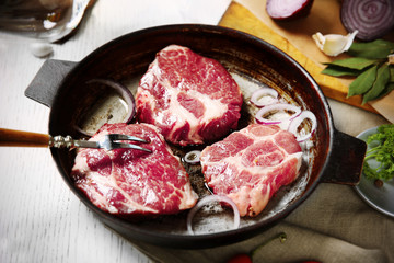 Marbled beef steak on pan and spices on color wooden background