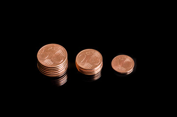 Three shrinking stacks of euro cent coins close-up