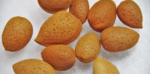 almonds whole lie on white glass