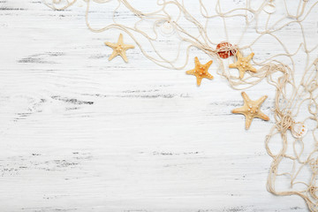 Seashells and fishing net on wooden background
