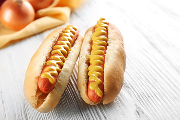 Hot dogs and fresh onions on wooden background