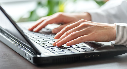 Female office worker typing on the keyboard.