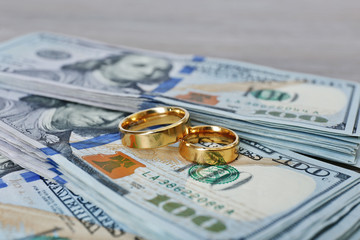 Wedding rings on money background, close up