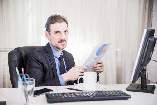 serious businessman sitting at his desk