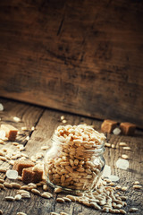 Sweet puffed rice with caramel in a glass jar on the old wooden