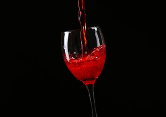 Wine pouring in glass on black background
