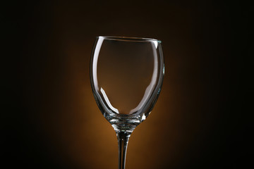 Empty wineglass on brown background